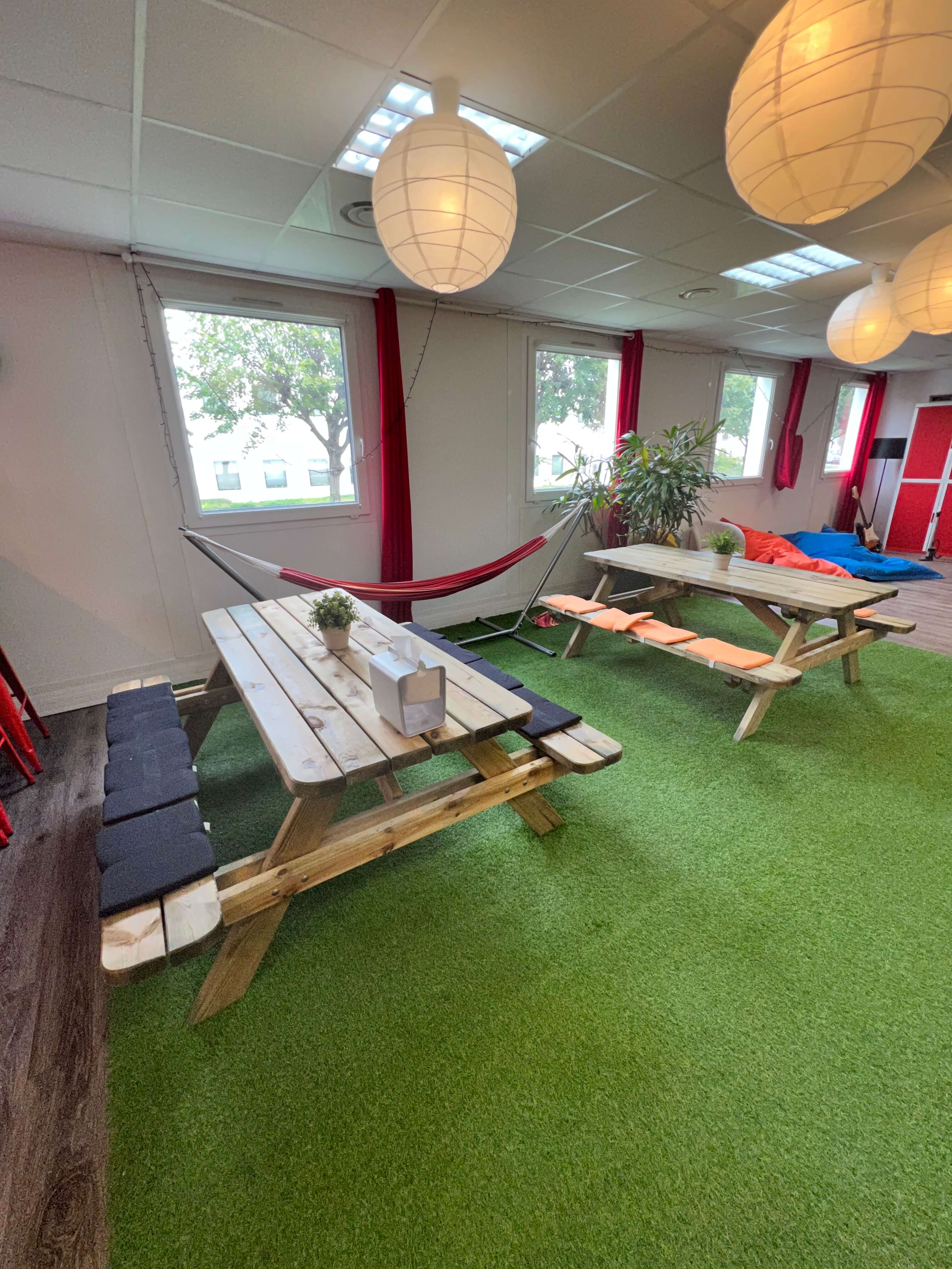 a room with a table and hammocks