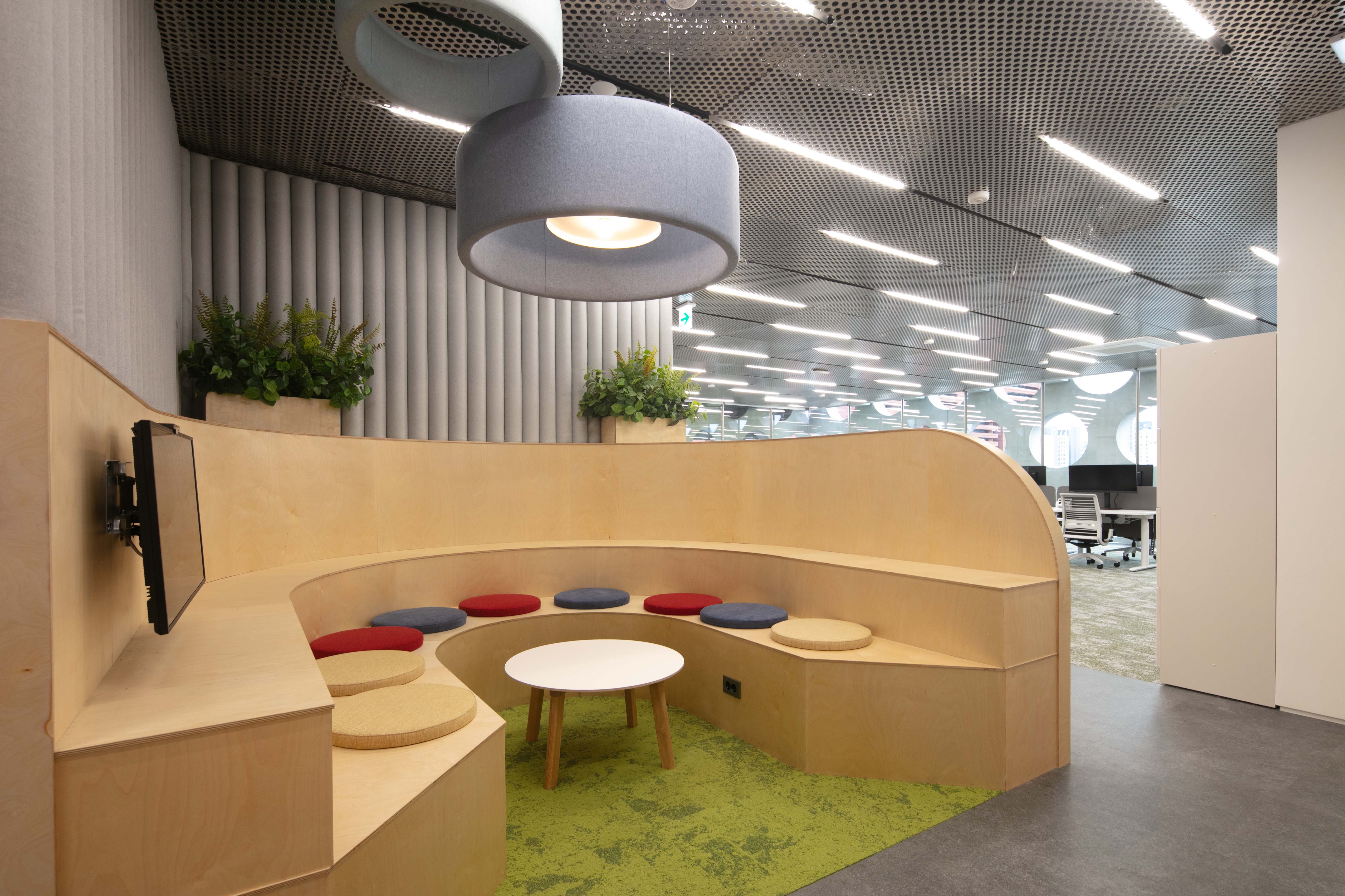 a round table and round stool in a room with a ceiling and plants