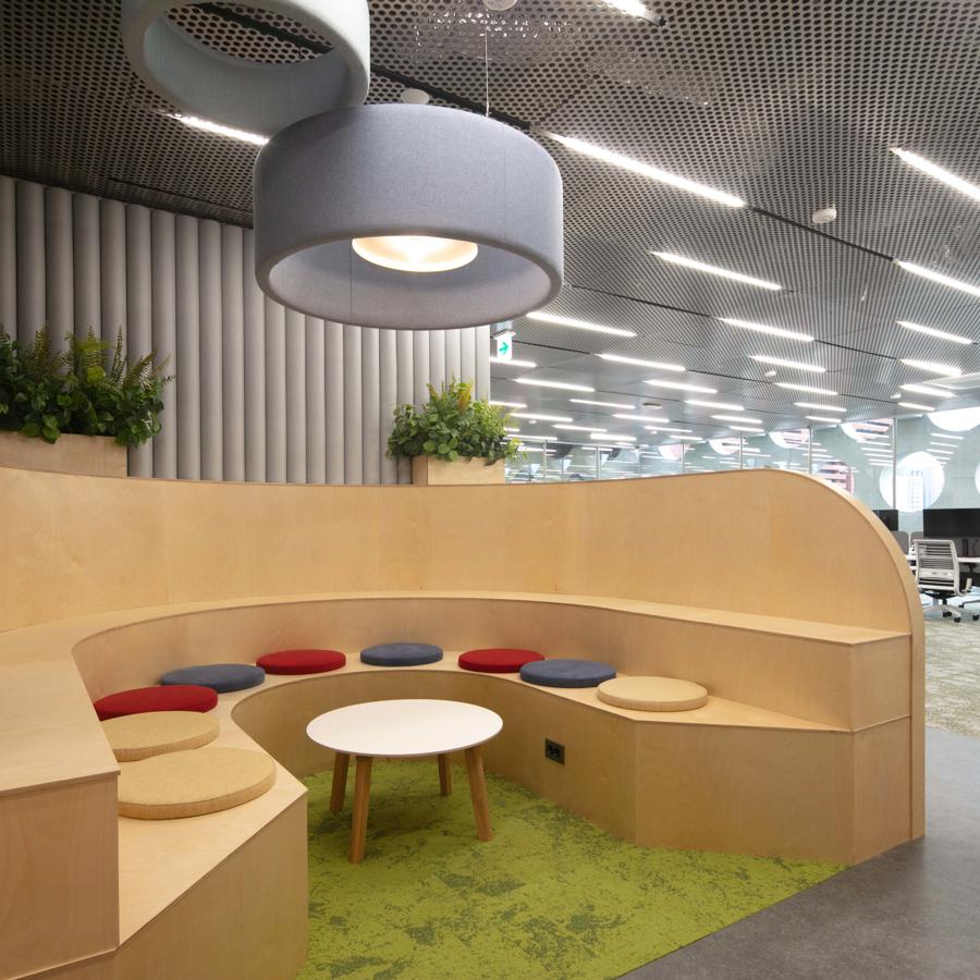 a round table and round stool in a room with a ceiling and plants