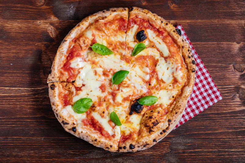 a pizza with basil on top