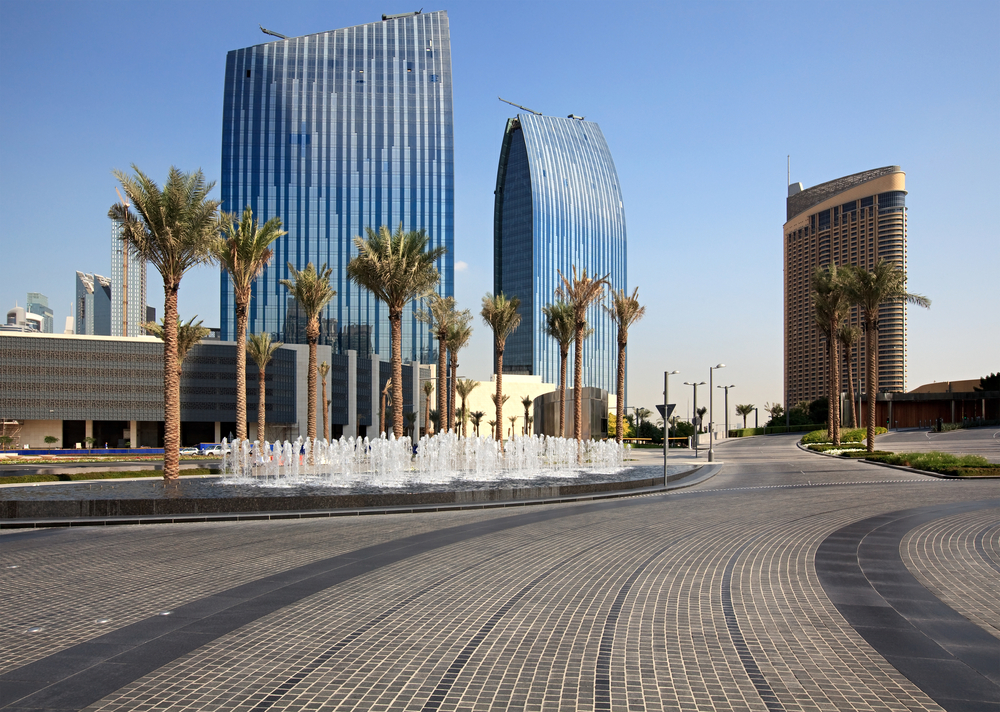 a street with a fountain and tall buildings