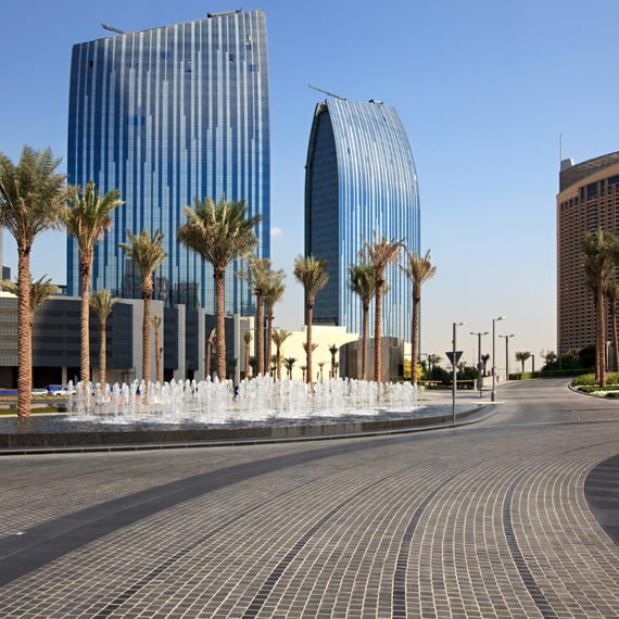 a street with a fountain and tall buildings