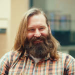 a man with long hair and beard smiling