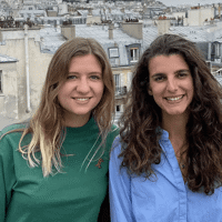 two women standing on a roof