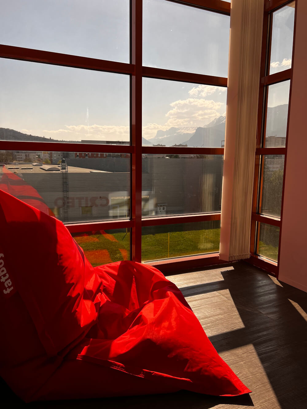 a red pillow next to a window