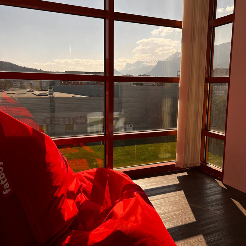 a red pillow next to a window