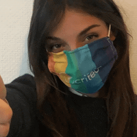 a woman wearing a rainbow colored face mask