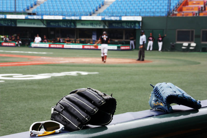a baseball glove and gloves on a bench