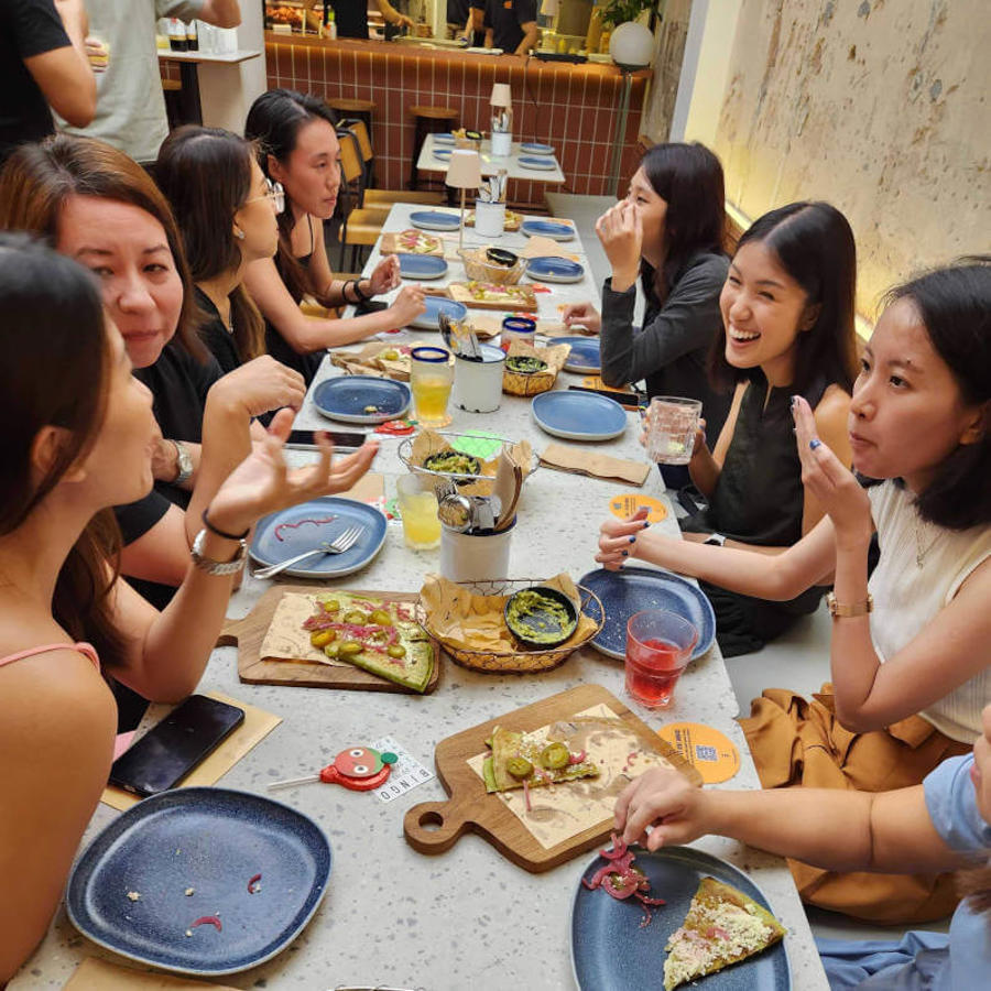 a group of women sitting around a table eating food