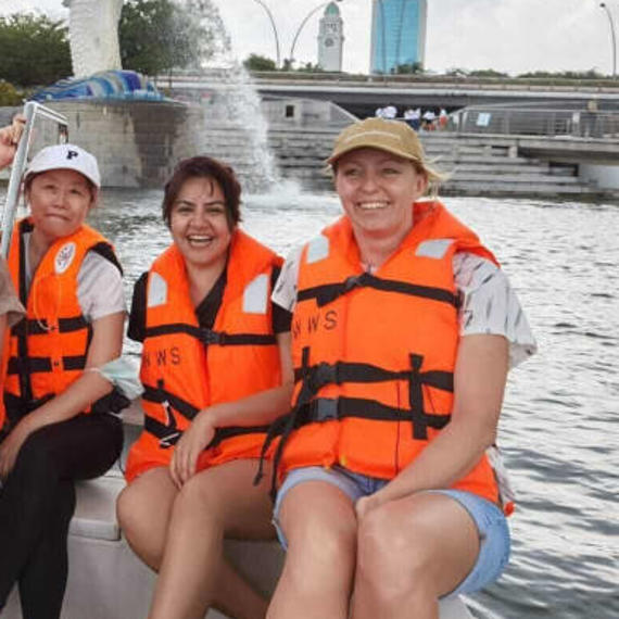 a group of people in life vests sitting on a boat