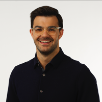 a man wearing glasses and smiling