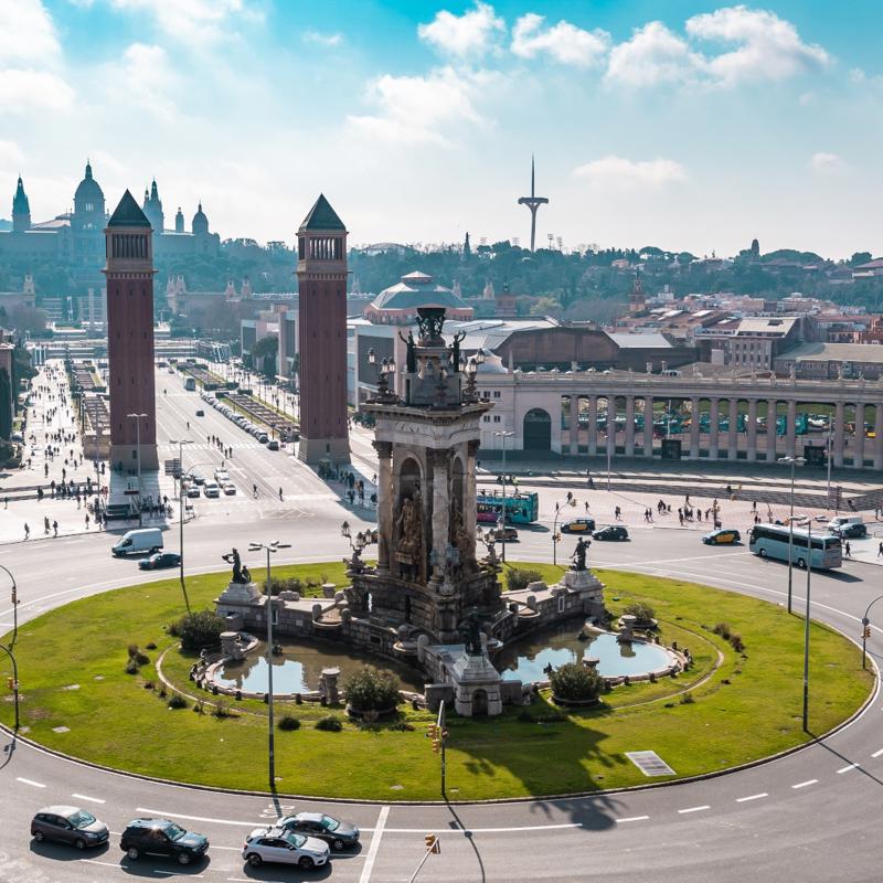 a circular road with a fountain and cars in the middle