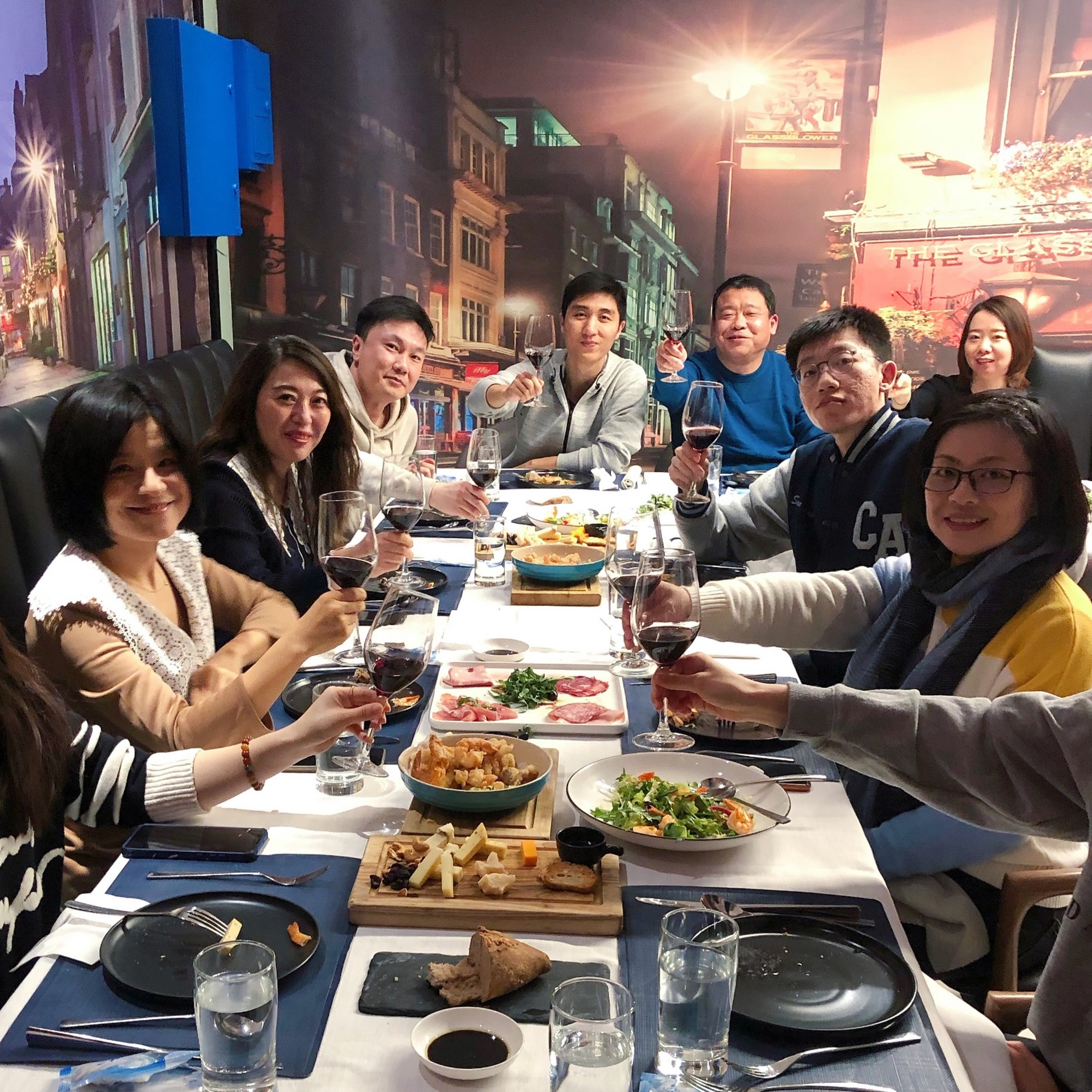 a group of people sitting at a table with food and drinks