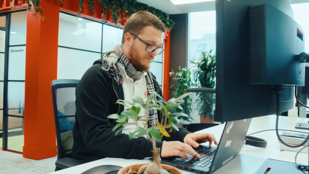 a man sitting at a desk using a laptop