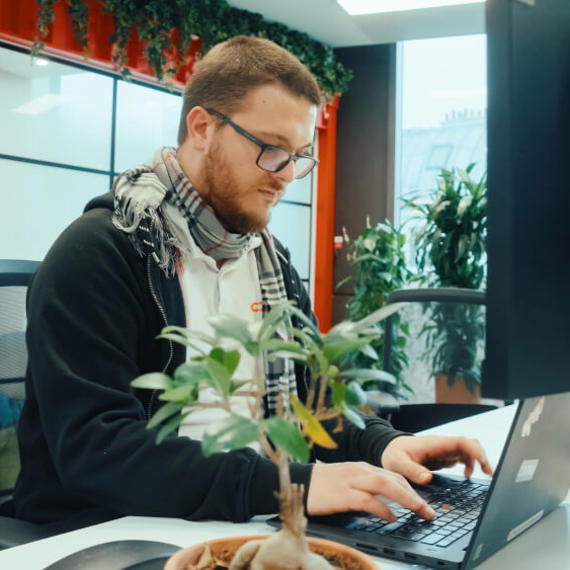 a man sitting at a desk using a laptop