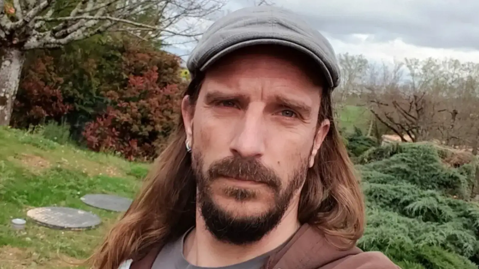 a man with long hair and a beard taking a selfie
